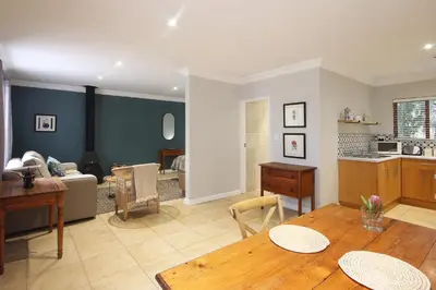 a living room with a table and a kitchen at Stony Brook Cottages in Franschhoek