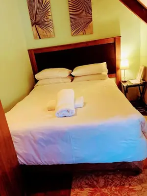 a large white bed with two towels on it at Zagorski’s Bed and breakfast in Bloubergstrand