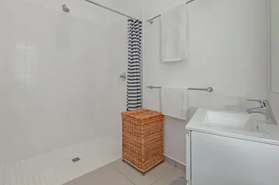 a white bathroom with a shower and a sink at Views Views Views in Hermanus
