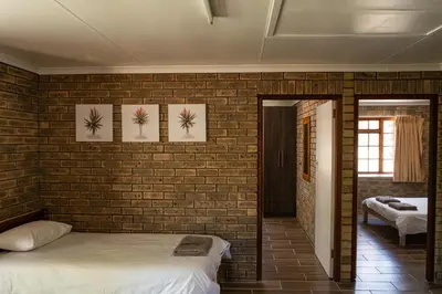 a bedroom with a brick wall and two beds at De Hollandsche Molen in Hou Moed