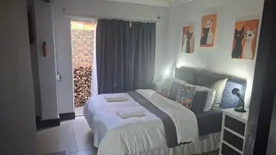 a bedroom with a bed in a room with a window at Robert's Place Paarl in Paarl