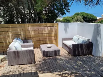 two chairs and a coffee table on a patio at Potluck Cottage in Hermanus