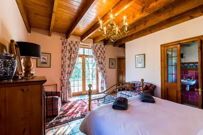 a bedroom with a bed and a chandelier at Die Wasbak in Greyton