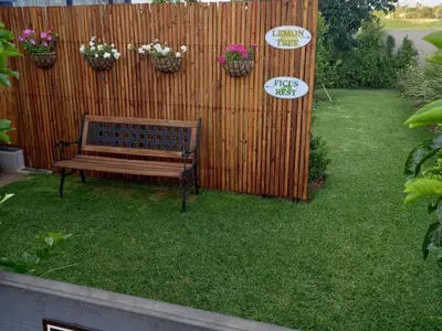 a wooden bench sitting in a yard next to a fence at Worcester the Karoo Guest Room in Worcester
