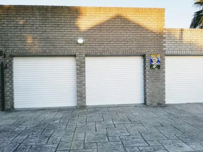 three white garage doors on a brick building at Arlogenix in Durbanville