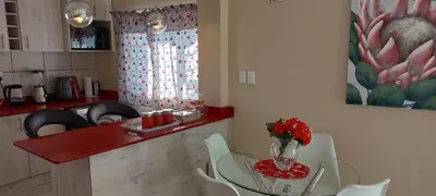 a kitchen with a table with a vase of flowers on it at Arlogenix in Durbanville