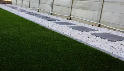 a row of rocks on the grass next to a building at Arlogenix in Durbanville
