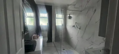 a white bathroom with a shower and a toilet at The Lily House Hermanus in Hermanus