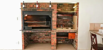 a brick oven with its door open in a kitchen at Riverside Villa in Gordonʼs Bay