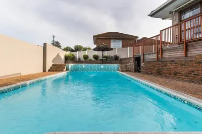 a swimming pool in the backyard of a house at Cornerstone Guesthouse Alk Van Zyl in Panorama