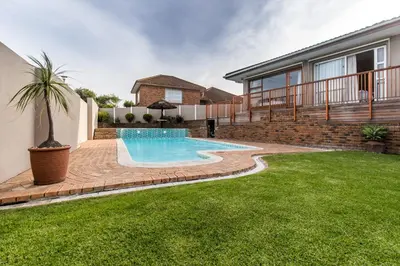 a swimming pool in the backyard of a house at Cornerstone Guesthouse Alk Van Zyl in Panorama