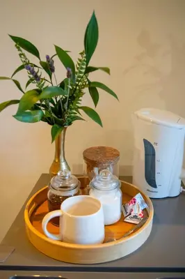 a tray with a coffee cup and a vase with flowers at Staymore in Stellenbosch