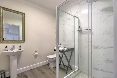 a bathroom with a shower and a toilet and a sink at Thyme Wellness Spa and Guesthouse in Cape Town