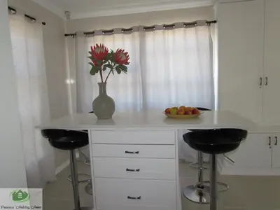 a kitchen with a counter with a vase of flowers at Princess Holiday Home in Cape Town