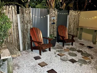 two chairs sitting on a patio with a fence at Silverdunes - Seaview in Bettyʼs Bay
