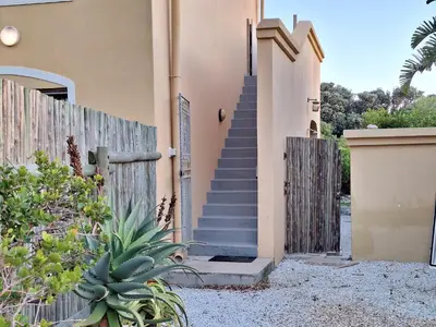 a house with a wooden fence and a staircase at Silverdunes - Seaview in Bettyʼs Bay