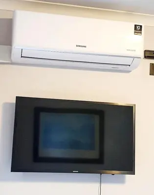 a television with a microwave above it on a wall at Mountain Rose Cottage in Bellville