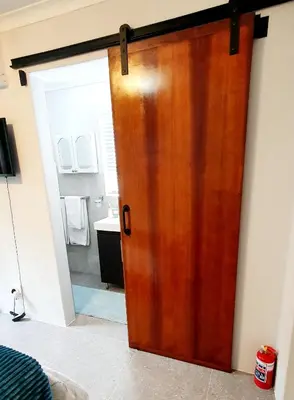a wooden door in a room with a bathroom at Mountain Rose Cottage in Bellville