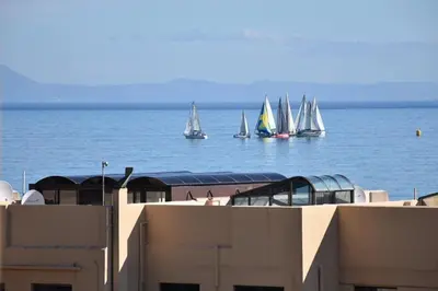 a group of sailboats in the water behind a building at Flavours at 34 in Gordonʼs Bay