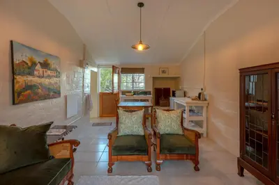 a living room with a couch and a table at Honeyrock Cottages in Kleinmond