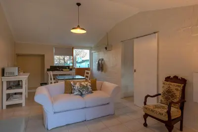 a living room with a white couch and a chair at Honeyrock Cottages in Kleinmond