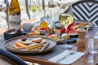 a table with plates of food and glasses of wine at Blaauwklippen Manor by NEWMARK in Stellenbosch