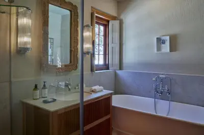 a bathroom with a tub and a sink and a mirror at Blaauwklippen Manor by NEWMARK in Stellenbosch