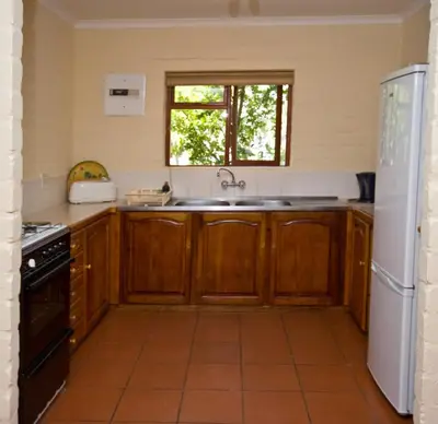 a kitchen with wooden cabinets and a sink at The Volmoed Trust in Hermanus