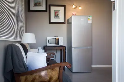 a living room with a refrigerator and a chair at The Vintage Crane Guest House in Caledon