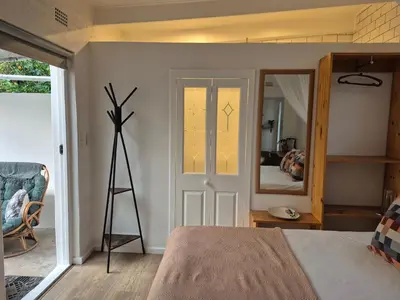 a bedroom with a bed and a mirror at 4 ON REGENT in Greyton