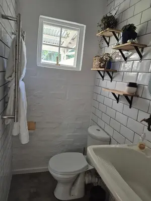 a bathroom with a toilet and a sink and a window at 4 ON REGENT in Greyton