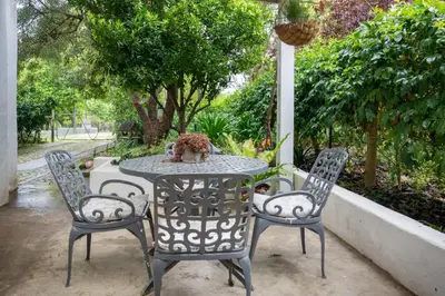 a patio table with two chairs and a vase on it at 4 ON REGENT in Greyton