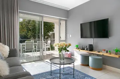a living room with a vase of flowers on a table at Century City Luxury Two Bedroom Apartment in Cape Town