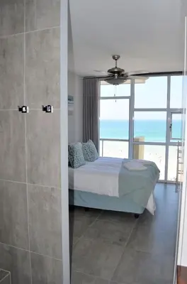 a bedroom with a bed and a view of the ocean at 808 St Tropez in Cape Town