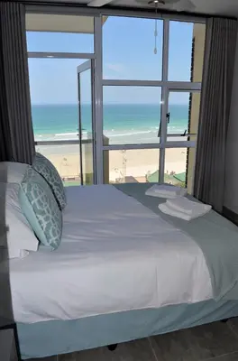 a bedroom with a bed with a view of the beach at 808 St Tropez in Cape Town