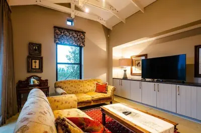 a living room with a couch and a flat screen tv at Farm Stay Winelands in Paarl