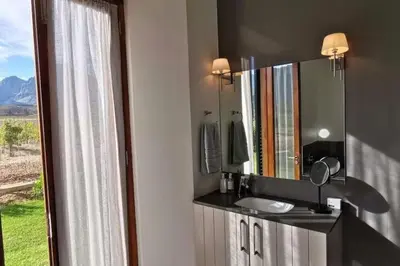 a bathroom with a sink and a mirror and a window at Farm Stay Winelands in Paarl