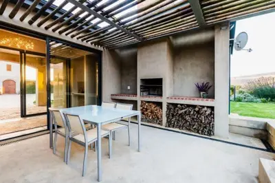 a table and chairs on a patio with a fireplace at Farm Stay Winelands in Paarl