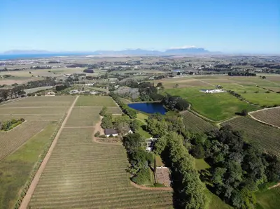 an aerial view of a farm with a lake at Navarre Farm Cottages in Stellenbosch