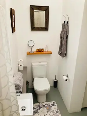 a small bathroom with a toilet and a mirror at Modern studio apartment in Cape Town