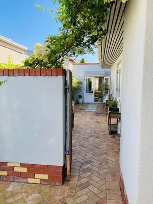 a house with a white fence and a patio at Modern studio apartment in Cape Town