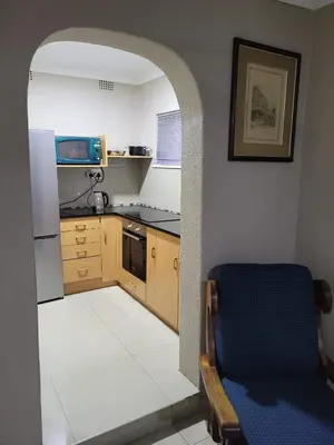 a kitchen with a table and a blue chair at MO MAJOR in Cape Town
