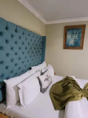 a bed with a blue head board and white pillows at MO MAJOR in Cape Town