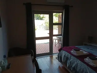 a bedroom with a door leading to a patio at 10 on Fairview B&B in Paarl