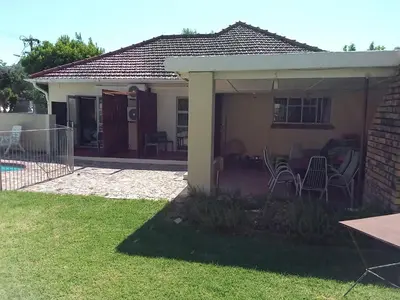 a house with a patio with chairs and a table at 10 on Fairview B&B in Paarl