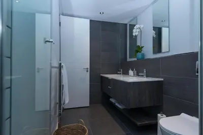 a bathroom with a sink and a glass shower at Six One Five at Matrix in Cape Town