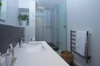 a bathroom with a tub and a glass shower at Six One Five at Matrix in Cape Town