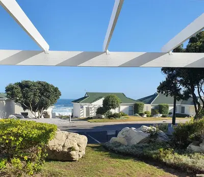 two pictures of a house and a view of a street at 57 Whale Rock Estate in Hermanus