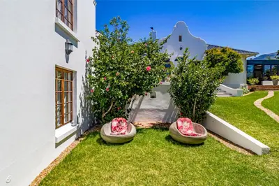 a garden with two baskets on the grass at La Bonne Auberge in Somerset West