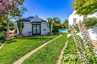 a yard with green grass and a house at La Bonne Auberge in Somerset West